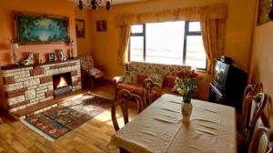 a living room with a table and a fireplace at The Bungalow in Doonbeg