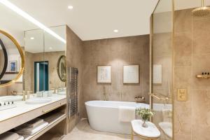 a bathroom with two sinks and a tub and a shower at Maison Albar Hotels L’Imperator in Nîmes