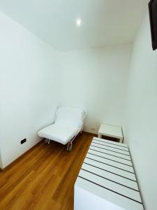 a white room with a bed and a chair at Agriturismo La Rustica in Cerratina