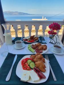 einen Tisch mit Teller mit Speisen auf dem Balkon in der Unterkunft Makla in Sarandë