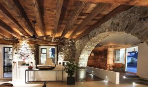 a living room with a stone wall and a ceiling at Pestana Fisherman Village in Câmara de Lobos