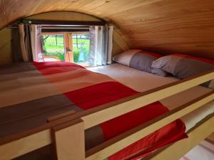 Habitación pequeña con 2 camas individuales y ventana. en Schlaffässer am Schmetterlingspark, en Uslar