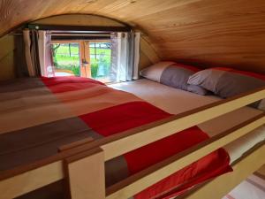 a twin bed in a small room with a window at Schlaffässer am Schmetterlingspark in Uslar