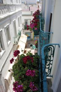 een trap met bloemen aan de zijkant van een gebouw bij AL - Alojamento Local Pension Bicuar in Olhão