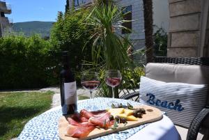 a bottle of wine and a plate of meat and cheese at Apartman Taraca Villa Knezevic in Herceg-Novi