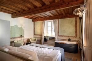 a bedroom with a large bed and a bath tub at Zlata Ladjica Boutique Hotel in Ljubljana