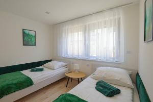 een slaapkamer met 2 bedden, een tafel en een raam bij Apartament Na Borach I SPA in Szczyrk