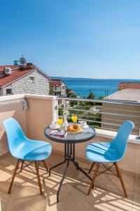 ポドストラナにあるSan Marian Apartmentsの海が見えるバルコニーにテーブルと椅子がある