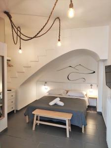 a bedroom with a bed with a bench in it at Villa Cinque Pini in Ischia