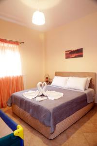 a bedroom with a bed with two towels on it at Zante Xigia Bay villas in Khartáta +37 photos