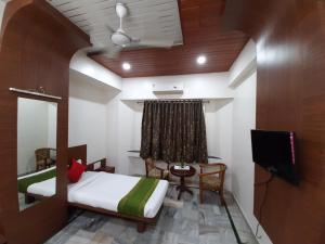a room with a bed and a tv in it at City Palace Hotel होटल सिटी पैलेस in Nashik