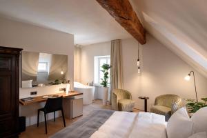 a bedroom with a bed and a desk and chairs at Zlata Ladjica Boutique Hotel in Ljubljana