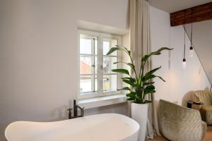a white chair and a plant in a room at Zlata Ladjica Boutique Hotel in Ljubljana