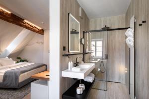 a bathroom with a sink and a shower and a bed at Zlata Ladjica Boutique Hotel in Ljubljana