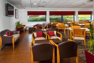 a waiting room with chairs and tables and windows at Holiday Inn Express Swansea East by IHG in Swansea