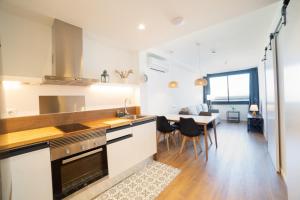 a kitchen and dining room with a table and chairs at Apartaments Voralmar in Caldes d'Estrac