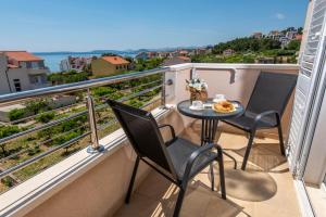 ポドストラナにあるSan Marian Apartmentsの椅子2脚と食事が置かれたテーブルが置かれたバルコニー +25枚の写真