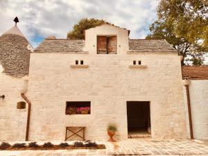 a large white brick building with a window at All'ombra dei lecci in Alberobello