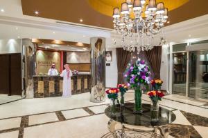 a lobby with a chandelier and a table with flowers at Boudl Al Maidan in Hafr Al-Batin
