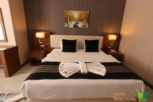 Una habitación de hotel con una cama con dos corbatas. en Royal Berk Hotel en Van