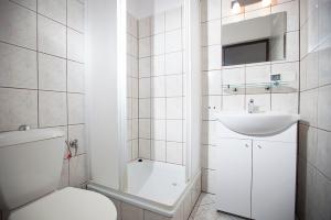 a white bathroom with a toilet and a sink at Pensjonat Bogdanka in Trzęsacz +43 photos