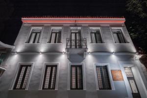 un edificio blanco con balcón por la noche en Twin Circle Athens en Atenas