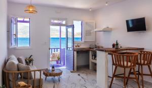 a kitchen and living room with a view of the ocean at The Colourful Land Milos in Klima