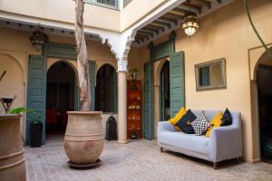 un patio al aire libre con sofá y jarrón en RIAD KERDOUSS, en Marrakech