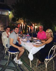 a group of people sitting around a table with candles at Riad Jean Claude in Fez