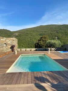 a swimming pool with a mountain in the background at Chambres d'hôtes et studios de charme - A Mandria in Murato