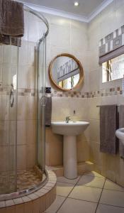 a bathroom with a sink and a shower at African Spirit Game Lodge in Manyoni Private Game Reserve