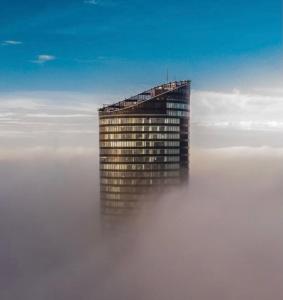 ein Gebäude in der Mitte einer Nebelschicht in der Unterkunft 30th+ Floor Apartments in Sky Tower in Breslau