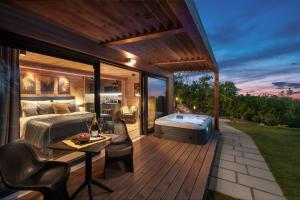 a bedroom and a deck with a bed and a hot tub at Szarvashegy Panoráma Apartman in Szentendre