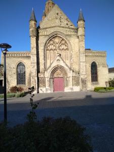 une grande église en pierre avec une porte rouge dans l'établissement chambre, à Calais