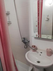 Baño blanco con lavabo y espejo en Аренда квартиры, en Izmaíl