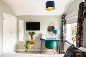 a bedroom with a blue table and a green chair at The Fromeway in Radstock