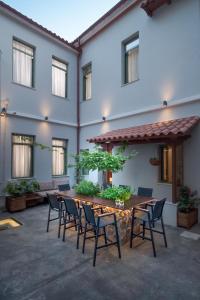 un patio con mesa y sillas frente a un edificio en Twin Circle Athens en Atenas