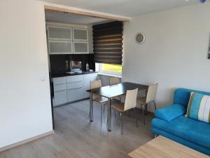 a kitchen and dining room with a table and a blue couch at Schöne Aussicht in Seelbach