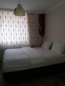 a bedroom with a bed and a window with curtains at Camlik Apart Hotel in Macka