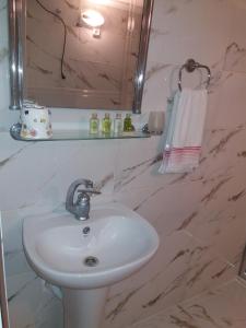 ein Badezimmer mit einem weißen Waschbecken und einem Spiegel in der Unterkunft Camlik Apart Hotel in Macka