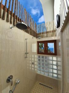 baño con ducha con ventana y puerta de cristal en Terrasse Sur Lazio en Anse Lazio