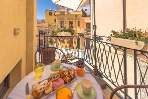 einen Tisch mit einem Tablett mit Speisen auf dem Balkon in der Unterkunft Design loft Marinella in Porticello in Santa Flavia