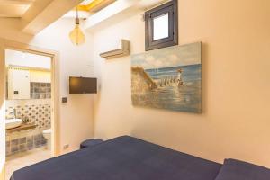 ein Schlafzimmer mit einem Bett und einem Wandgemälde in der Unterkunft Design loft Marinella in Porticello in Santa Flavia