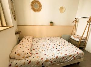 a bedroom with a bed with a comforter on it at New! Cosy T2 au coeur de la ville - climatisation - coin terrasse in Aix-en-Provence