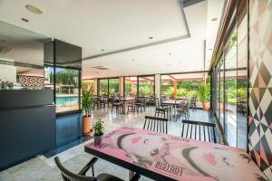 a dining room with a table and chairs and windows at Topazio Vibe Beach Hotel & Apartments - Adults Friendly in Albufeira