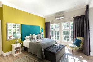 a bedroom with a bed with a blue and yellow wall at Taunton Manor in Pietermaritzburg