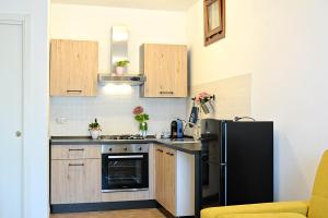 a small kitchen with a black refrigerator and wooden cabinets at LA PIGNA mare, collina, Ravenna, Mirabilandia, Cottignola in Ghibullo +37 photos