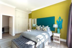 a bedroom with a bed and a blue and yellow wall at Taunton Manor in Pietermaritzburg