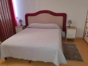 ein Schlafzimmer mit einem großen Bett mit einer weißen Tagesdecke in der Unterkunft Parque das Amendoeiras in Vilamoura