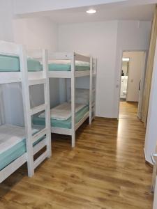 a room with three bunk beds and a wooden floor at Hotel hostel Zafir in Berlin